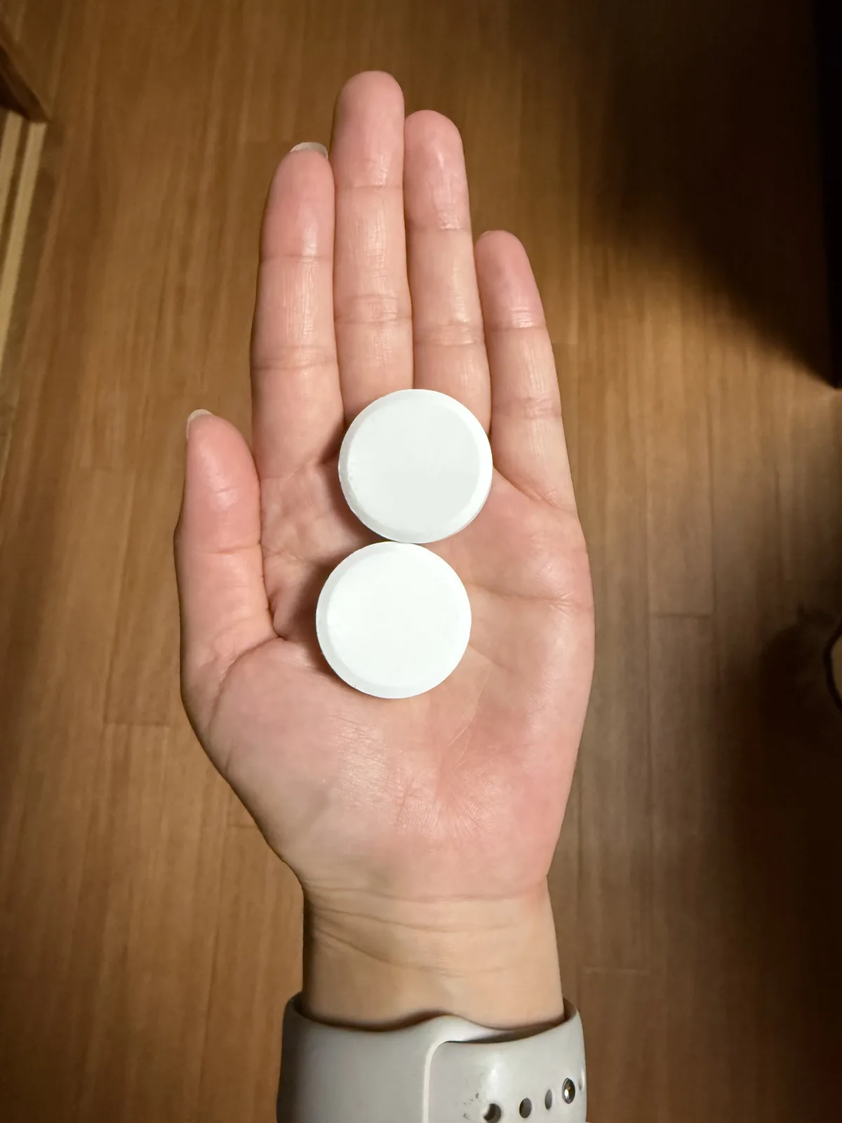 手のひらにのせたBARTHとホットタブ WELLNESSのタブレット2つ。見分けがつかない
