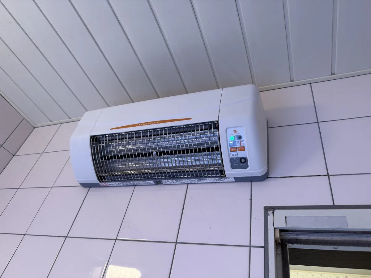 浴室の壁の上のほうに取りつけた換気乾燥暖房機