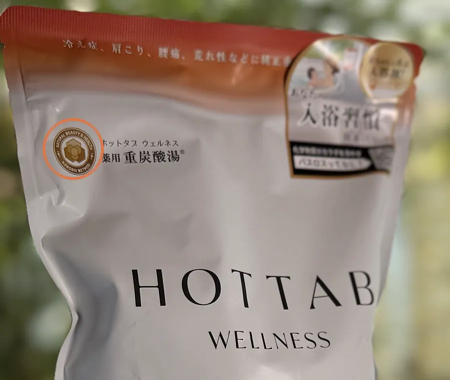 HOT TAB WELLNESSの袋の表面。左上の金色の丸いKOBOSHI METHODマークを丸で囲んだ写真