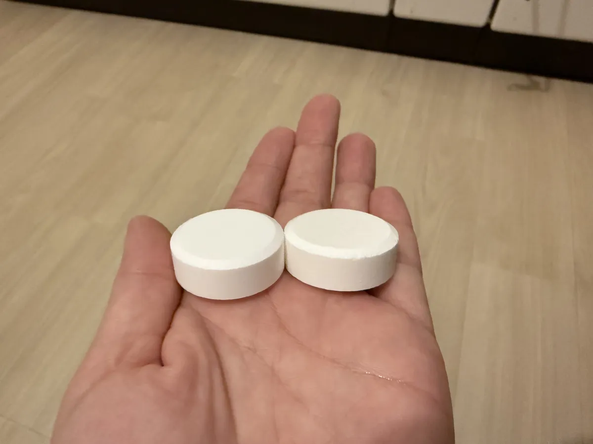 手のひらにのせたRECOVERY（左）とWELLNESS（右）のタブレット